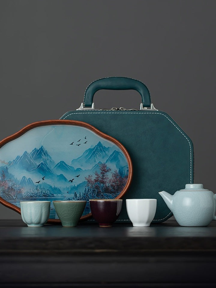 Complete portable tea set with a Xishi teapot, four tasting cups, landscape tray, and teal travel case
