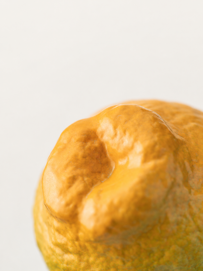 Stacked green-to-orange tangerine-shaped ceramic teacups with a close view of the fruit-like base