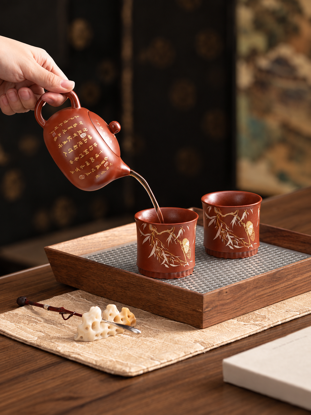 Yixing zisha teapot with two matching tea cups on a traditional tea table