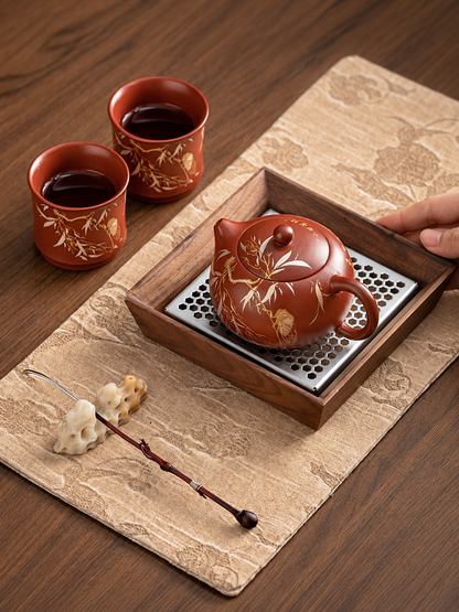 Zisha Xishi teapot and two cicada-pattern cups arranged for gongfu tea