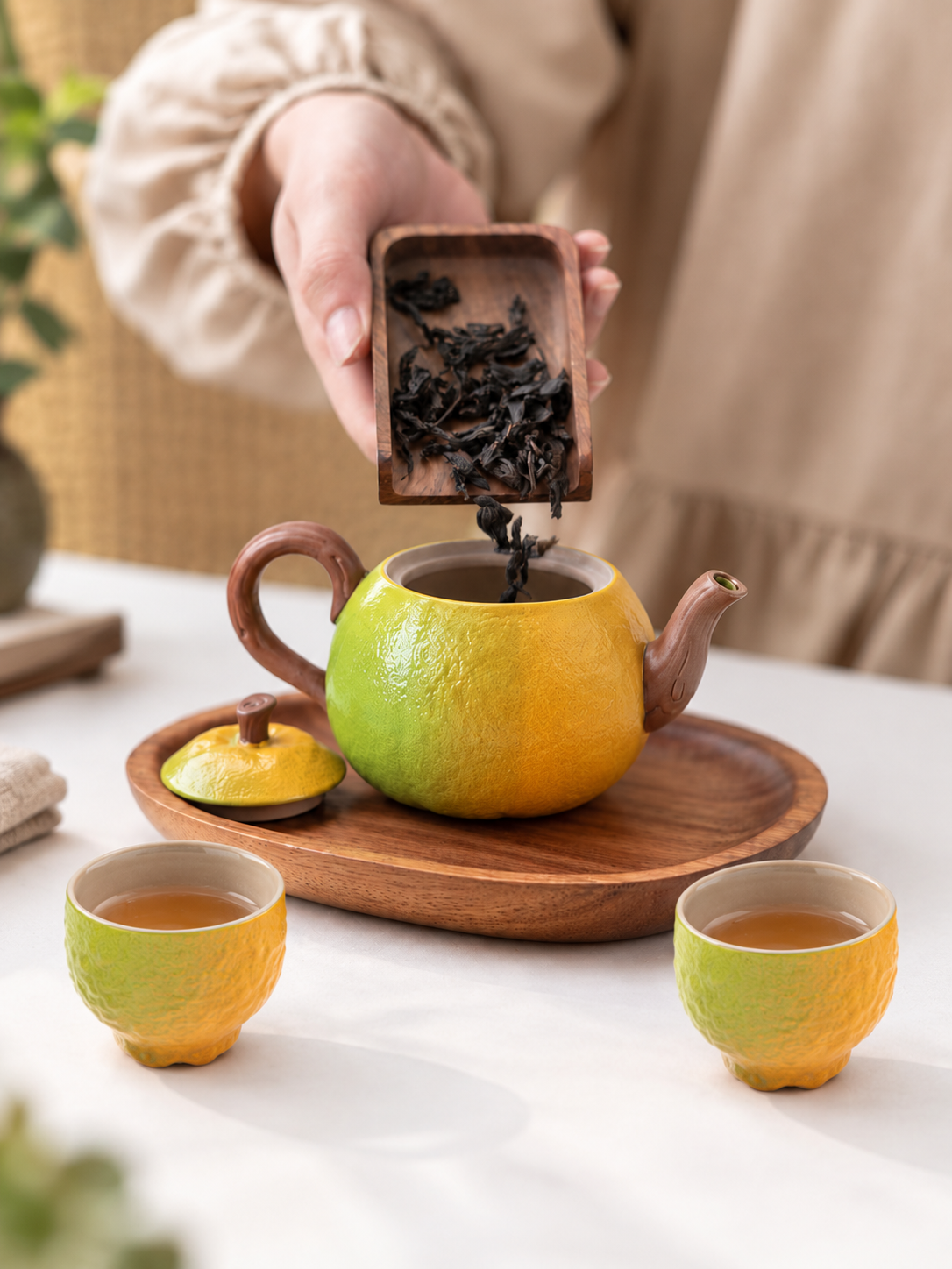 Add loose-leaf tea to the green-to-orange gradient orange-shaped ceramic teapot