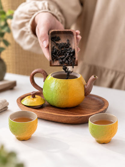 Add loose-leaf tea to the green-to-orange gradient orange-shaped ceramic teapot