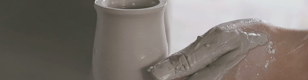 Unfired porcelain cups arranged in a quiet workshop